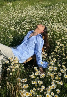 Woman lying in a field of German chamomile