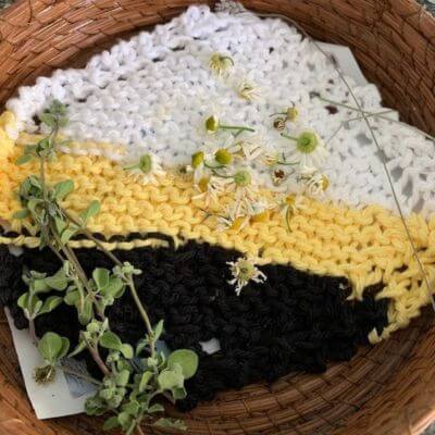 Chamomile flowers drying in a basket with Greek marjoram on the left