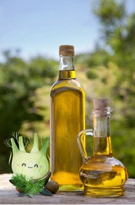 Bottles of olive oil with a bulb of fennel on the side