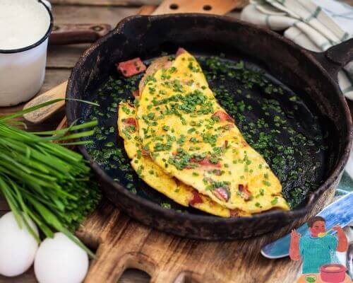 Omelet in cast iron frying pan with chives 