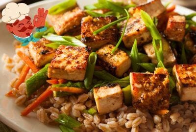 Fried tofu cubes on plate with cooked grain